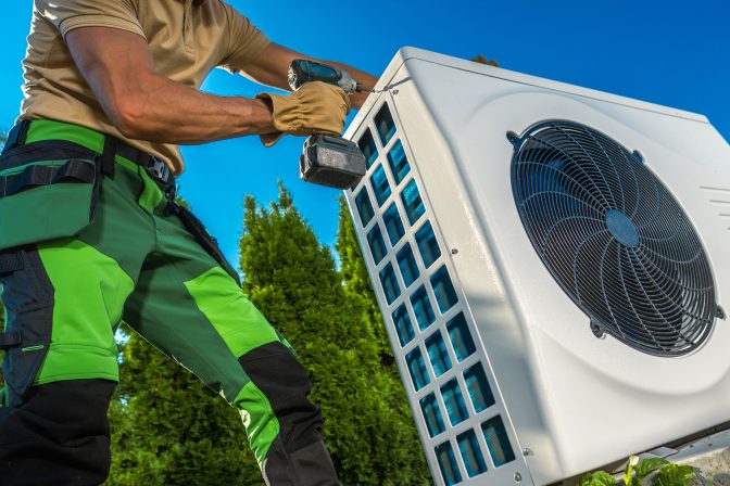 HVAC Technician Installing Large Modern Heat Pump